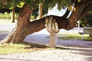 Tree branch held up by hand sculpture
