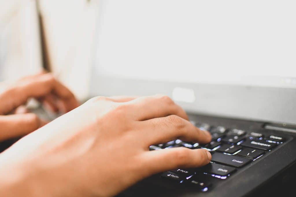 Close of up hands typing on a laptop keyboard