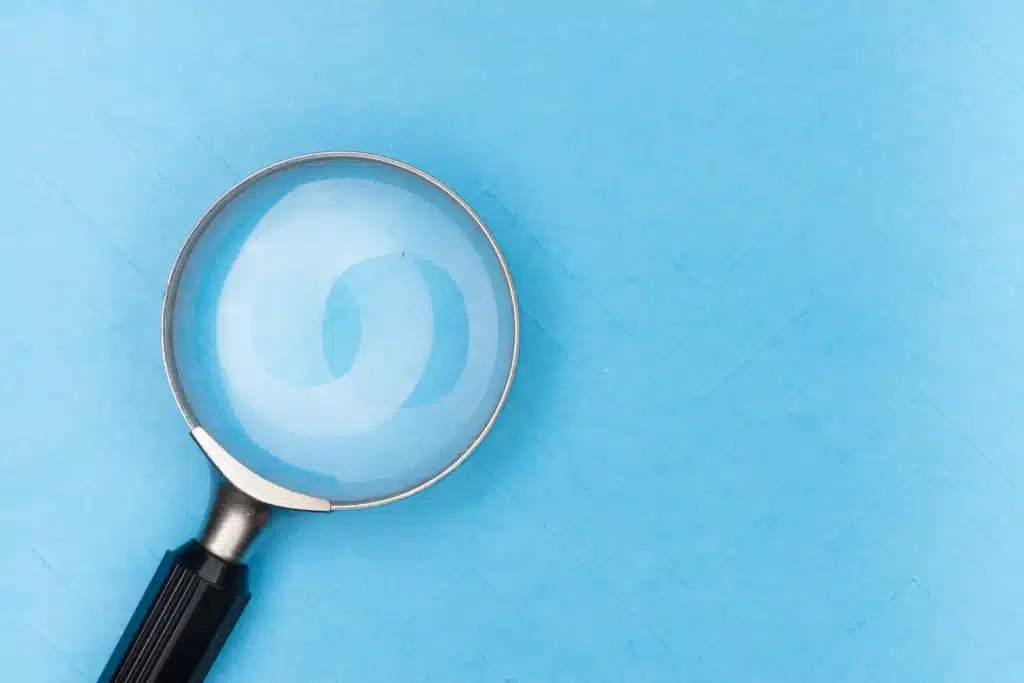 The Benefits Of Audits 9 Magnifying glass with a black handle on a blue background