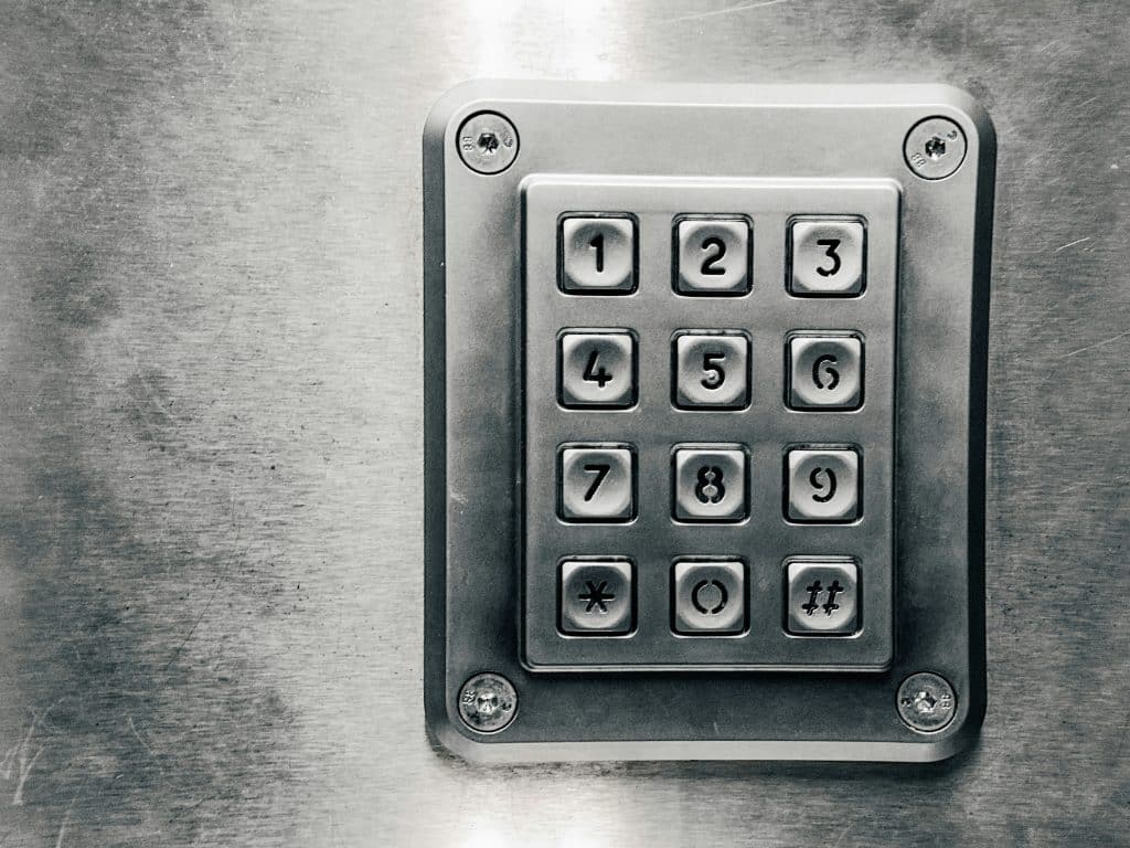 What Is A Physical Security Audit? 5 A grey metal pin pad with numbers 0 to 9 is secured to a grey wall.