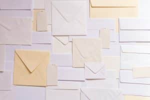 Subject Access Request - envelopes are spread across a table in a variety of shapes and sizes, in various shades of yellow, cream and white.