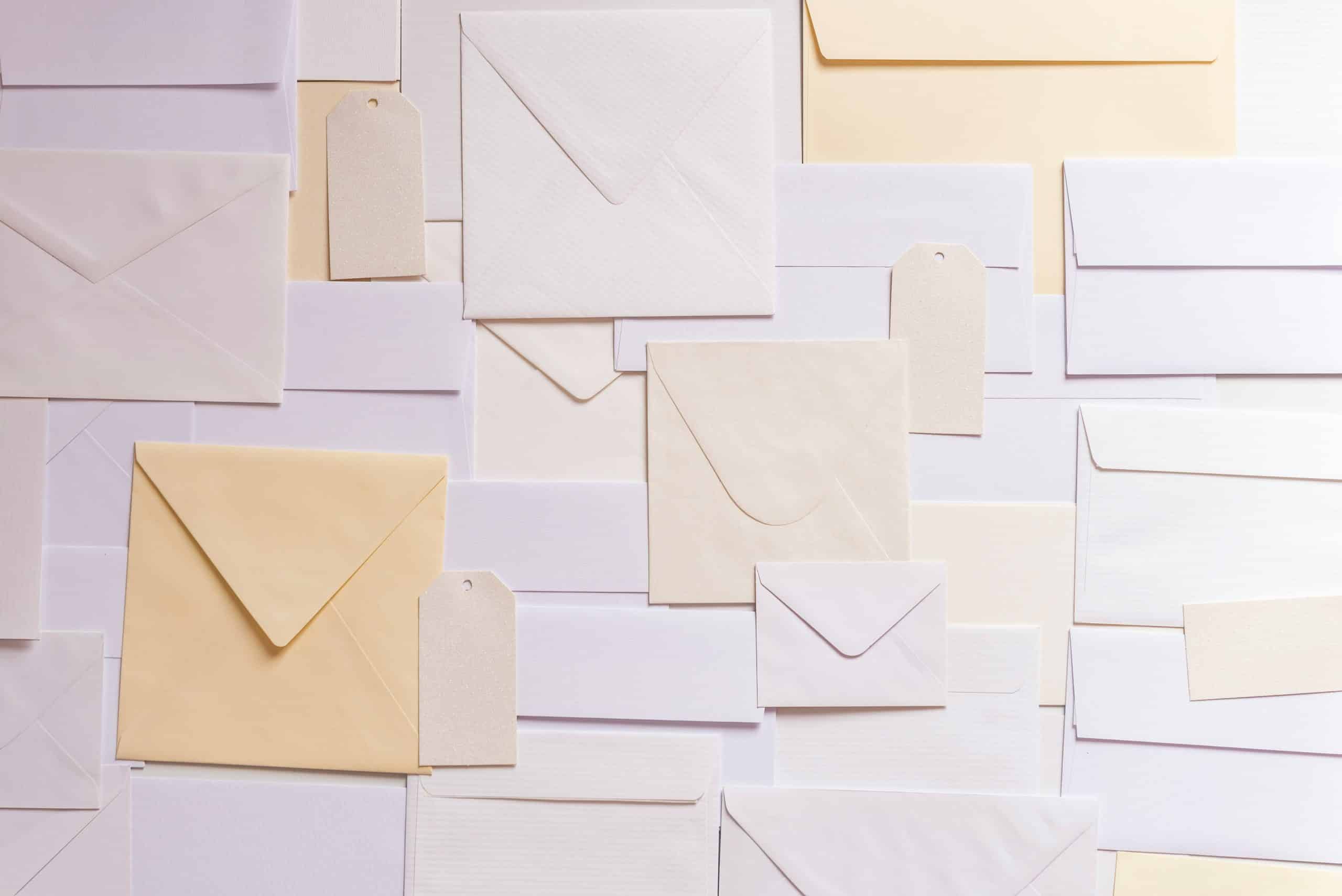 Subject Access Request - envelopes are spread across a table in a variety of shapes and sizes, in various shades of yellow, cream and white.