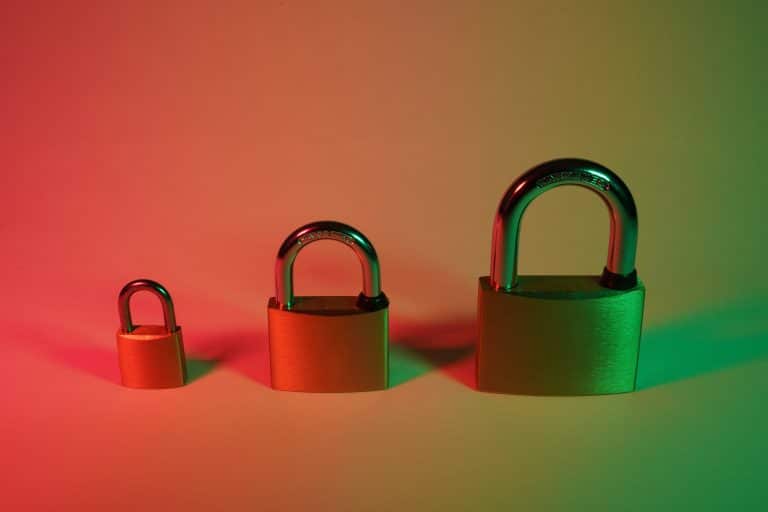 Three padlocks sit on a red, orange and green lit background, representing the different levels of the DSPT.