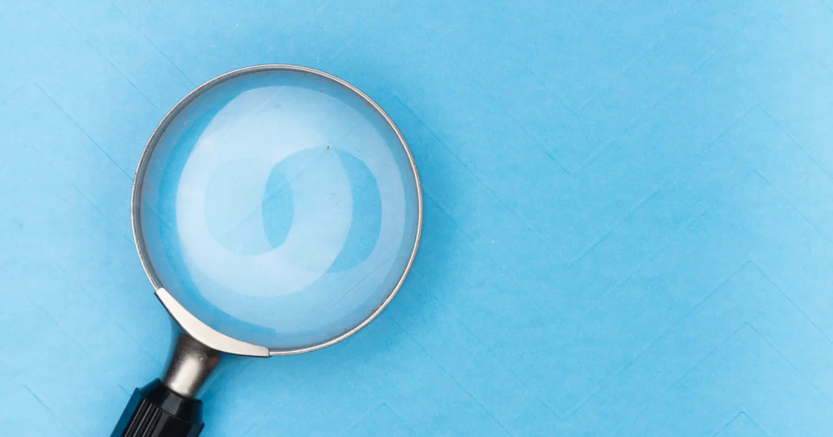 Magnifying glass with a black handle on a blue background